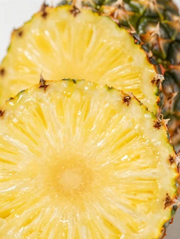 Piña fresca cortada en rodajas sobre mesa de madera rústica