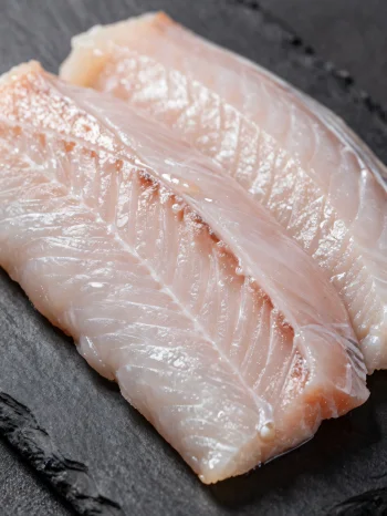 Filetes de anguila fresca con especias sobre tabla de madera
