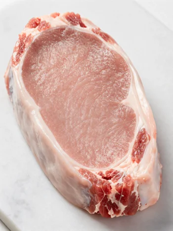 Trozos de carne de ternera fresca clara con especias sobre tabla