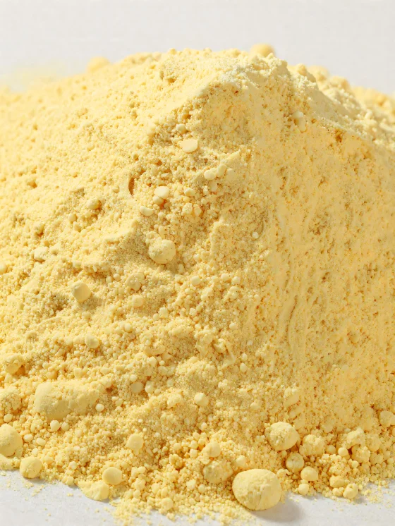 Harina de maíz amarilla en polvo en cuenco de cerámica sobre madera