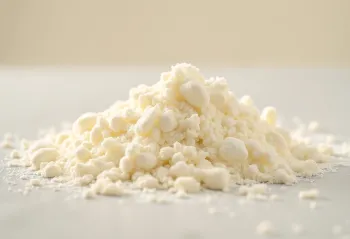 Leche en polvo en cuenco y cuchara de madera sobre mesa