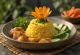 Tumpeng con tempeh, un exótico plato indonesio, arroz rico, tempeh tostado y verduras frescas