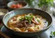 Hủ tiếu con ternera, servido con caldo rico y fideos de arroz