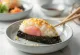 Onigiri triangular envuelto con nori y cubierto de sésamo