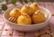 Loukoumades con miel y nueces, buñuelos dorados en plato, bañados en miel y espolvoreados con nuez
