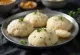 Idli rava recién hecho, al vapor, decorado con hojas de cilantro fresco