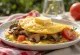 Tortilla de champiñones con tomate, decorada con perejil fresco