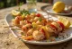 Brochetas de marisco a la parrilla servidas con verduras y perejil fresco