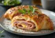 Stromboli de pechuga de pavo servido, con abundante pavo y mozzarella fundida por encima, crujiente por fuera y suave por dentro.