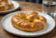 Bretzels veganos recién horneados servidos en una tabla de madera rústica