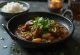 Curry de cabra con ajo, preparado con leche de coco, servido con cilantro fresco