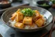 Katsudon de tofu relleno en salsa de soja, servido con cebolleta fresca