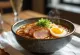 Bol de ramen con jamón asado, fideos y guarniciones