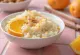 Risengrød cremoso servido con piel de naranja recién rallada y canela